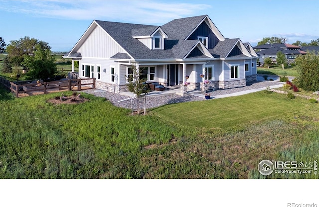 505 Nesting Eagles Way, Berthoud, CO 80513 - rear view of property with stone siding, a lawn, board and batten siding, and a shingled roof