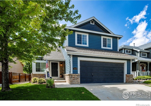 5609 Mount Sanitas Ave, Longmont, CO 80503 - view of front of house with concrete driveway, brick siding, a garage, and a shingled roof