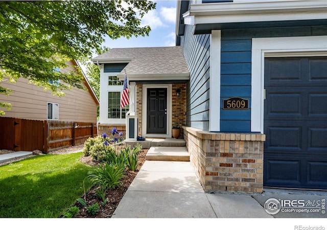 5609 Mount Sanitas Ave, Longmont, CO 80503 - view of exterior entry featuring a garage and a shingled roof