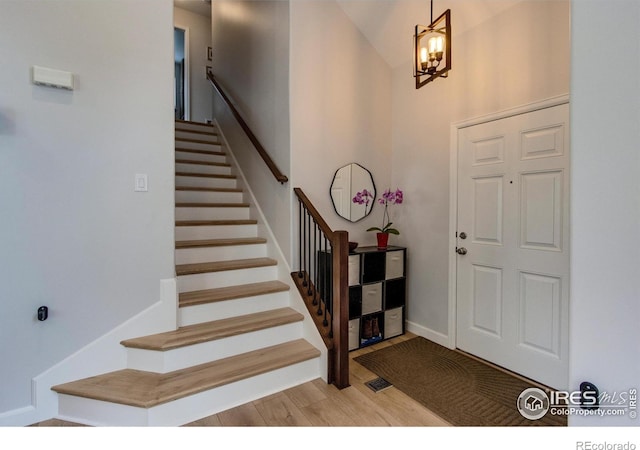 5609 Mount Sanitas Ave, Longmont, CO 80503 - foyer entrance with stairway, light wood-style floors, a chandelier, and baseboards