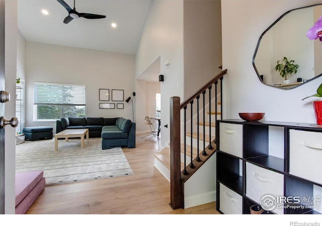 5609 Mount Sanitas Ave, Longmont, CO 80503 - living area featuring plenty of natural light, ceiling fan, high vaulted ceiling, wood finished floors, and stairway