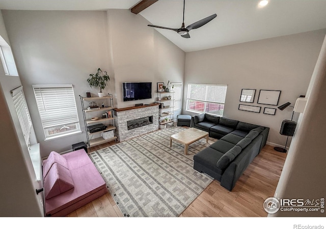 5609 Mount Sanitas Ave, Longmont, CO 80503 - living room with high vaulted ceiling, ceiling fan, wood finished floors, beamed ceiling, and a stone fireplace