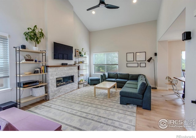 5609 Mount Sanitas Ave, Longmont, CO 80503 - living area with high vaulted ceiling, plenty of natural light, wood finished floors, a fireplace, and a ceiling fan