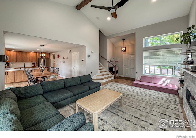 5609 Mount Sanitas Ave, Longmont, CO 80503 - living room featuring high vaulted ceiling, a chandelier, stairway, a ceiling fan, and beam ceiling