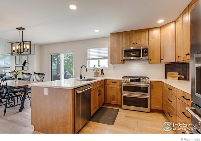 5609 Mount Sanitas Ave, Longmont, CO 80503 - kitchen featuring stainless steel appliances, a sink, light wood-style floors, decorative backsplash, and recessed lighting
