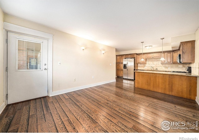 233 N Meldrum St Unit 8, Fort Collins, CO 80521 - kitchen with stainless steel appliances, dark wood-style flooring, brown cabinetry, hanging light fixtures, and tasteful backsplash