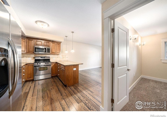 233 N Meldrum St Unit 8, Fort Collins, CO 80521 - kitchen featuring stainless steel appliances, brown cabinets, a peninsula, decorative backsplash, and baseboards