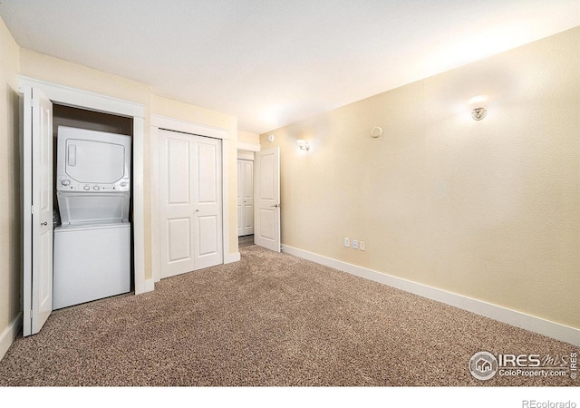233 N Meldrum St Unit 8, Fort Collins, CO 80521 - unfurnished bedroom with stacked washer and clothes dryer, carpet floors, baseboards, and a closet