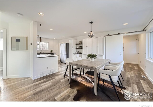 1498 Wicklow St, Boulder, CO 80303 - dining room featuring plenty of natural light, light wood-style flooring, recessed lighting, and a barn door
