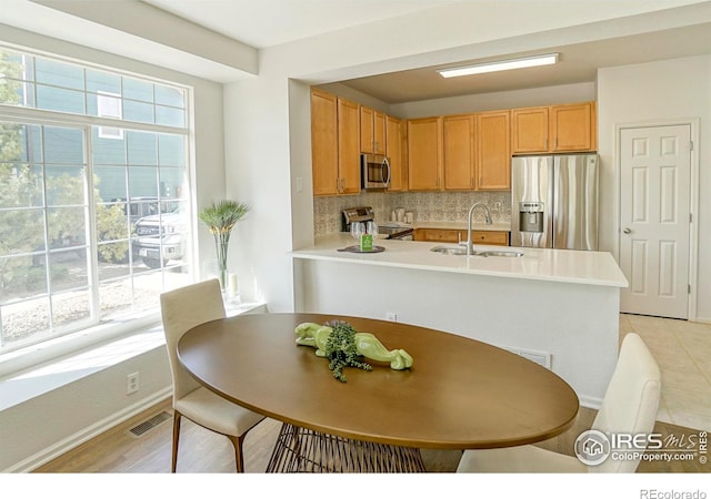 2855 Rock Creek Cir Unit 233, Superior, CO 80027 - kitchen featuring appliances with stainless steel finishes, tasteful backsplash, light countertops, and a peninsula