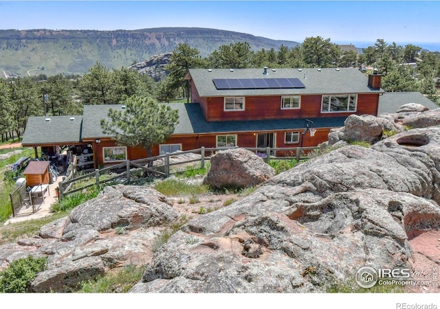 1960 Colard Ln, Lyons, CO 80540 - back of house with roof mounted solar panels, a mountain view, and a chimney