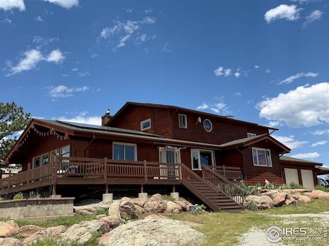 1960 Colard Ln, Lyons, CO 80540 - view of front facade featuring a chimney, a deck, and an attached garage