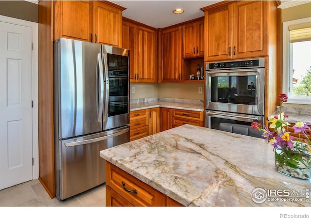 1960 Colard Ln, Lyons, CO 80540 - kitchen with appliances with stainless steel finishes, light stone countertops, brown cabinetry, light tile patterned floors, and recessed lighting