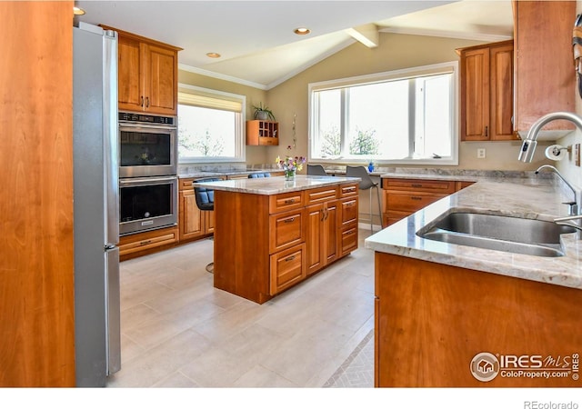 1960 Colard Ln, Lyons, CO 80540 - kitchen featuring brown cabinetry, appliances with stainless steel finishes, light stone countertops, crown molding, and a center island