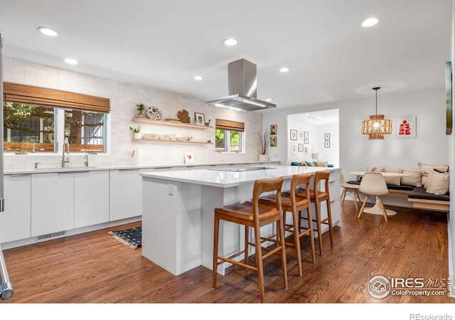 3490 16th St, Boulder, CO 80304 - kitchen with island exhaust hood, white cabinets, wood finished floors, a kitchen island, and light countertops