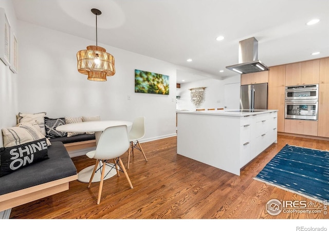 3490 16th St, Boulder, CO 80304 - kitchen with island exhaust hood, stainless steel appliances, a kitchen island, light wood-style floors, and recessed lighting