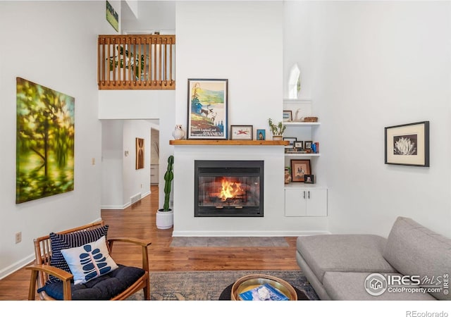3490 16th St, Boulder, CO 80304 - living area featuring wood finished floors, a glass covered fireplace, and a high ceiling