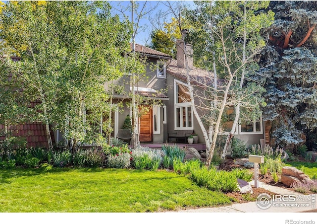 3490 16th St, Boulder, CO 80304 - view of front of house with stucco siding, a front yard, a chimney, and a tiled roof