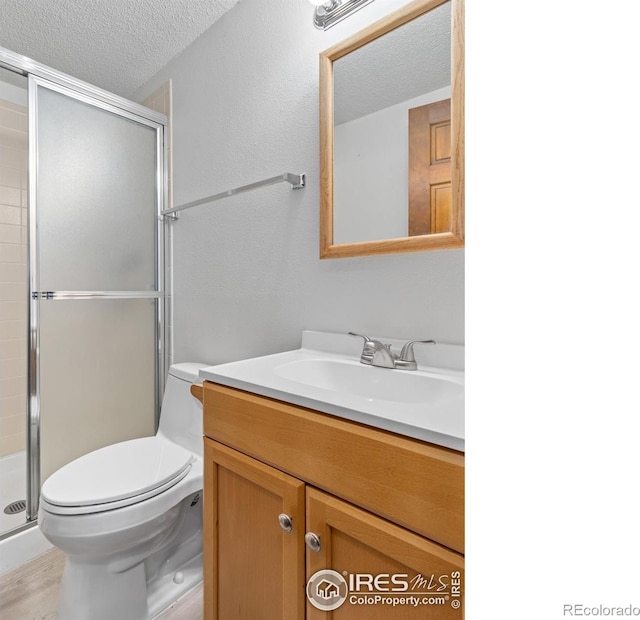 621 Landers St, Estes Park, CO 80517 - full bath with a textured ceiling, vanity, a shower stall, and wood finished floors