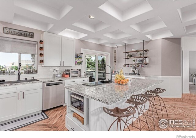 1451 Red Fox Cir, Severance, CO 80550 - kitchen featuring open shelves, stainless steel appliances, a kitchen breakfast bar, coffered ceiling, and white cabinets