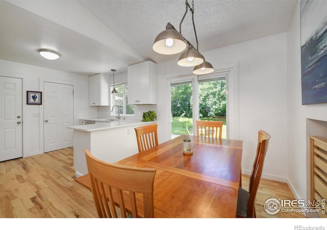 137 S Polk Ave, Louisville, CO 80027 - dining area with light wood-style floors, lofted ceiling, and a textured ceiling