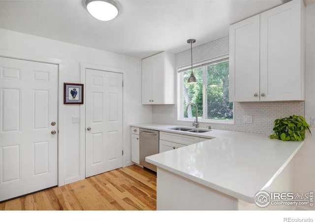 137 S Polk Ave, Louisville, CO 80027 - kitchen with stainless steel dishwasher, light wood-style floors, light countertops, white cabinets, and a peninsula