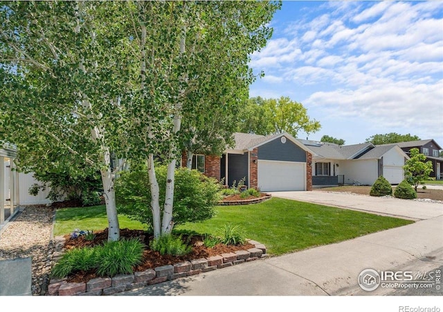 110 50th Ave, Greeley, CO 80634 - view of front facade featuring a garage, brick siding, a front yard, and driveway