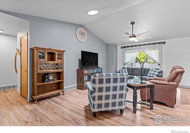 110 50th Ave, Greeley, CO 80634 - living room featuring a textured ceiling, light wood-style floors, vaulted ceiling, and a ceiling fan