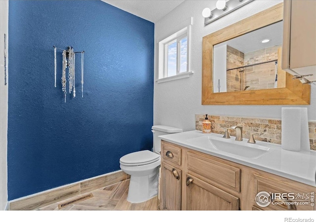 110 50th Ave, Greeley, CO 80634 - full bath featuring vanity, tiled shower, a textured wall, and backsplash