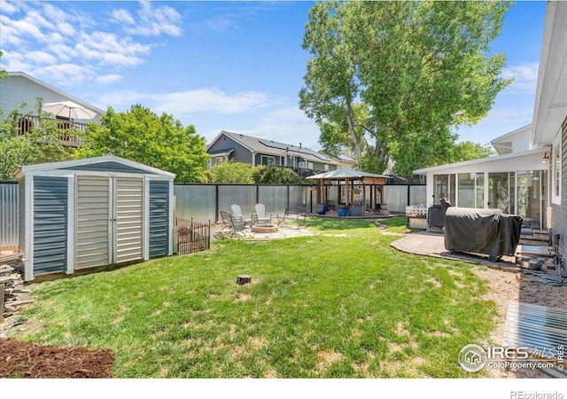110 50th Ave, Greeley, CO 80634 - fenced backyard featuring a gazebo, a fire pit, a storage shed, a patio area, and a sunroom