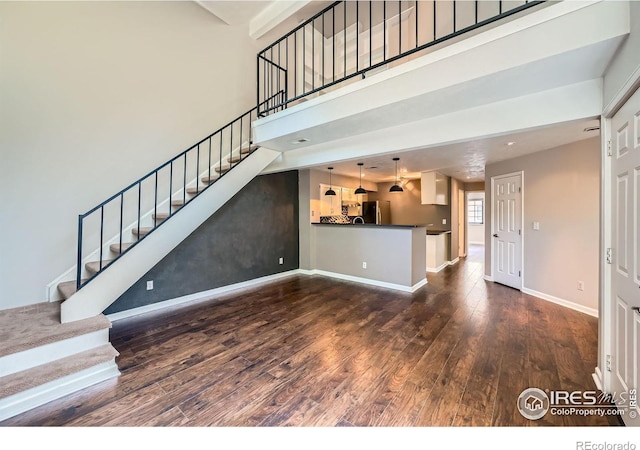 4771 White Rock Cir Unit B, Boulder, CO 80301 - unfurnished living room featuring wood finished floors, stairs, and a towering ceiling