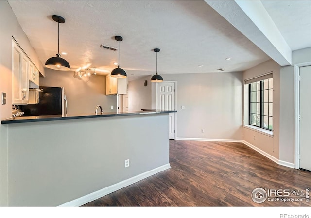 4771 White Rock Cir Unit B, Boulder, CO 80301 - kitchen featuring dark wood finished floors, a peninsula, fridge, pendant lighting, and white cabinetry