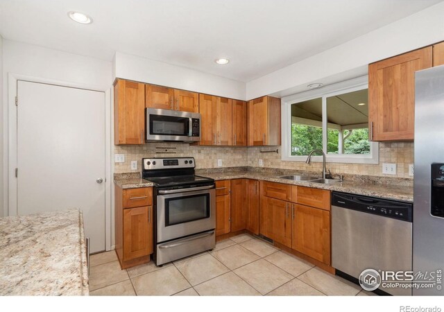 1512 Brentwood Dr, Fort Collins, CO 80521 - kitchen with appliances with stainless steel finishes, brown cabinets, tasteful backsplash, light tile patterned flooring, and recessed lighting