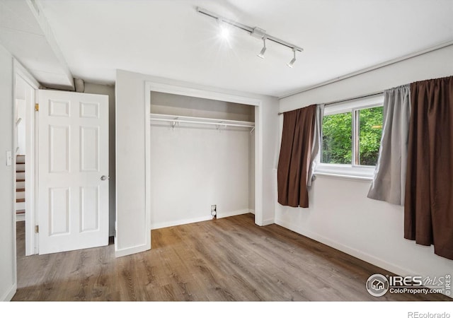 1512 Brentwood Dr, Fort Collins, CO 80521 - unfurnished bedroom with rail lighting, wood finished floors, and a closet