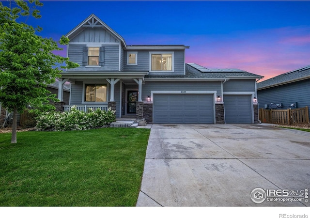 6420 Tuxedo Park Rd, Timnath, CO 80547 - craftsman house featuring covered porch, driveway, solar panels, a garage, and stone siding
