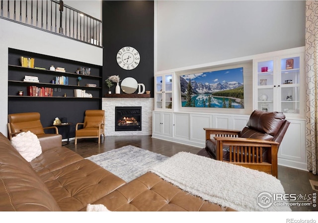 6420 Tuxedo Park Rd, Timnath, CO 80547 - living room with wood finished floors, built in features, a lit fireplace, and a high ceiling