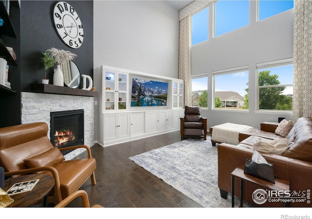 6420 Tuxedo Park Rd, Timnath, CO 80547 - living area featuring a high ceiling, wood-type flooring, and a stone fireplace