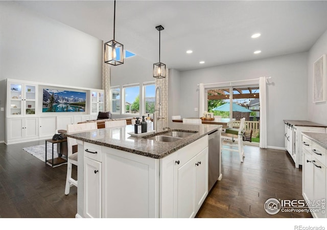 6420 Tuxedo Park Rd, Timnath, CO 80547 - kitchen featuring stainless steel dishwasher, dark wood-style floors, an island with sink, white cabinetry, and recessed lighting