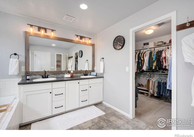 6420 Tuxedo Park Rd, Timnath, CO 80547 - bathroom with double vanity, a walk in closet, tiled tub, and recessed lighting