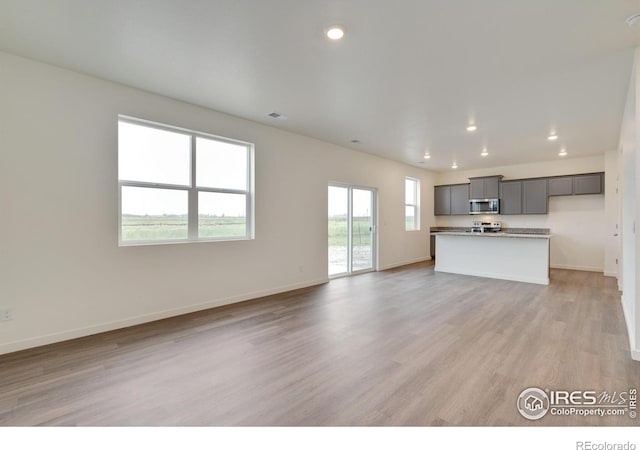 1639 Pinnacle Ave, Lochbuie, CO 80603 - unfurnished living room featuring light wood-style floors and recessed lighting