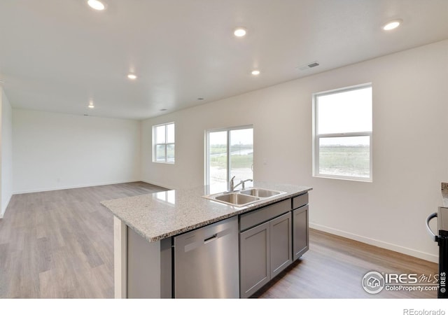 1639 Pinnacle Ave, Lochbuie, CO 80603 - kitchen with stainless steel dishwasher, gray cabinetry, light wood-style floors, an island with sink, and recessed lighting