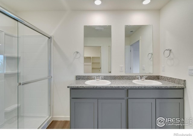 1639 Pinnacle Ave, Lochbuie, CO 80603 - full bath featuring double vanity, a shower stall, wood finished floors, and recessed lighting