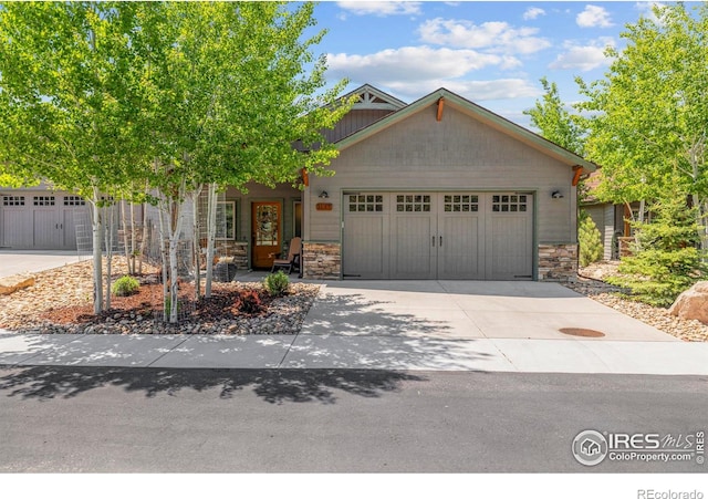 1137 Fish Creek Rd, Estes Park, CO 80517 - craftsman-style home with stone siding, a garage, and concrete driveway