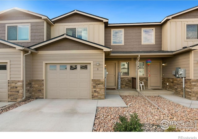 3145 Alybar Dr # 16B, Wellington, CO 80549 - townhome / multi-family property with stone siding, covered porch, a garage, and driveway