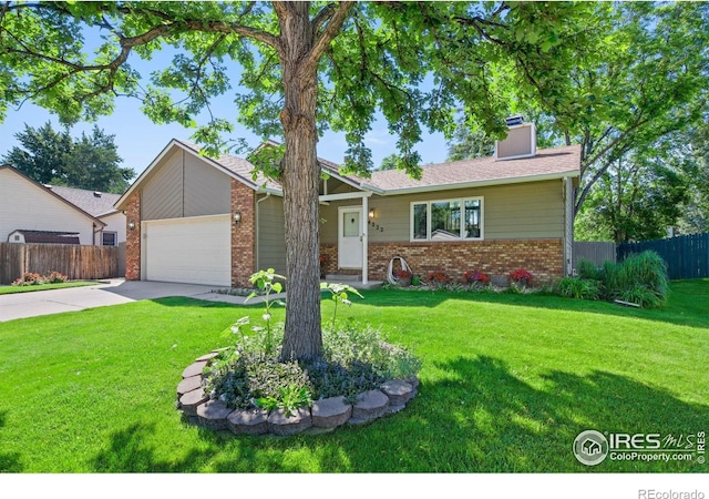 4222 W 22nd Street Rd, Greeley, CO 80634 - view of front of home with brick siding, driveway, a garage, and a chimney