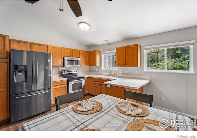 1144-1148 E 5th St, Loveland, CO 80537 - kitchen with appliances with stainless steel finishes, ceiling fan, light countertops, vaulted ceiling, and brown cabinets