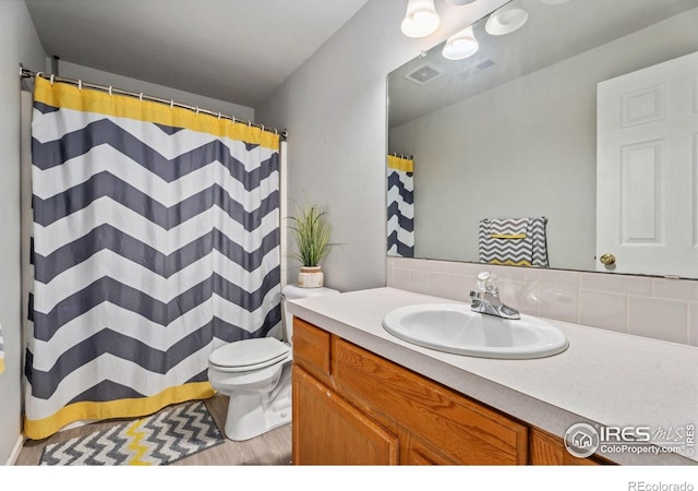 1144-1148 E 5th St, Loveland, CO 80537 - bathroom with vanity, wood finished floors, decorative backsplash, and a shower with shower curtain