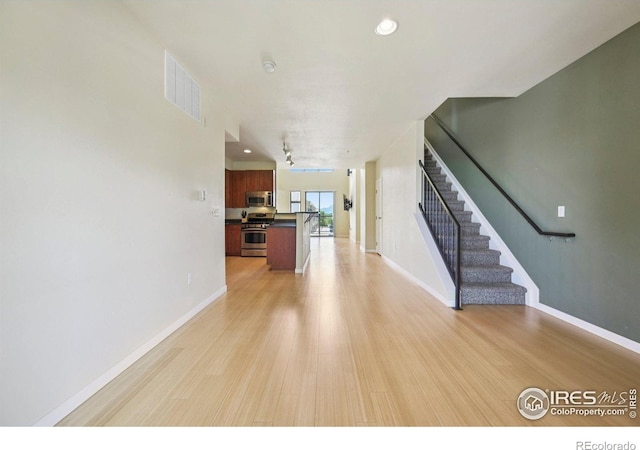 1200 Yarmouth Ave Unit 237, Boulder, CO 80304 - unfurnished living room with light wood-type flooring, stairs, and recessed lighting