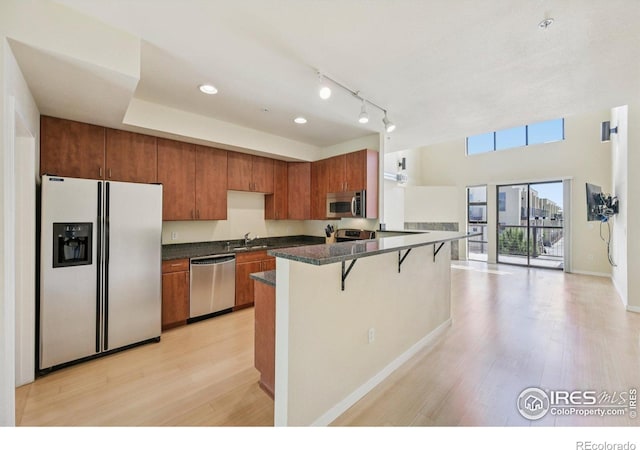 1200 Yarmouth Ave Unit 237, Boulder, CO 80304 - kitchen with stainless steel appliances, a peninsula, dark countertops, brown cabinetry, and recessed lighting