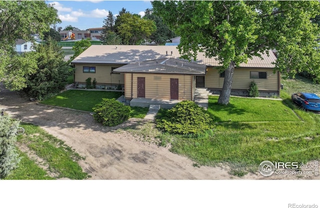 205-207 W Corona Ave, Wiggins, CO 80654 - view of front of home with a front yard and a metal roof